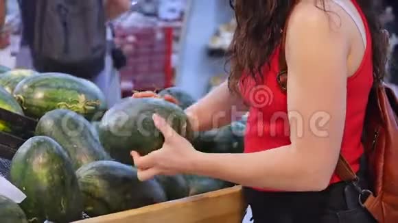 漂亮的年轻女人或母亲在超市购物选择食物西瓜鳄梨水果胡萝卜视频的预览图
