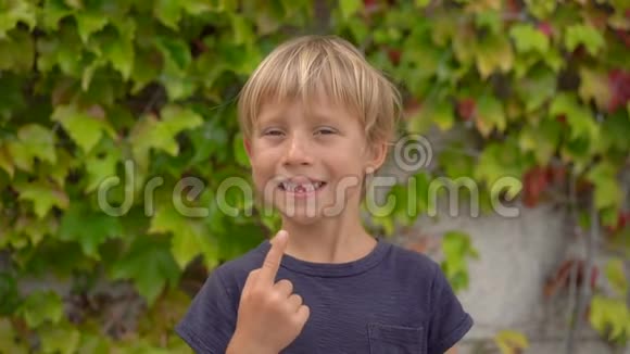 一个小男孩展示了他的乳牙准备脱落慢镜头视频的预览图