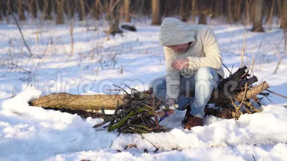一个人在冬天的森林里点燃了一个打火机视频的预览图