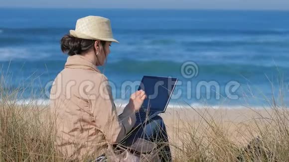阳光海滩上与朋友在线交流的快乐女人视频的预览图