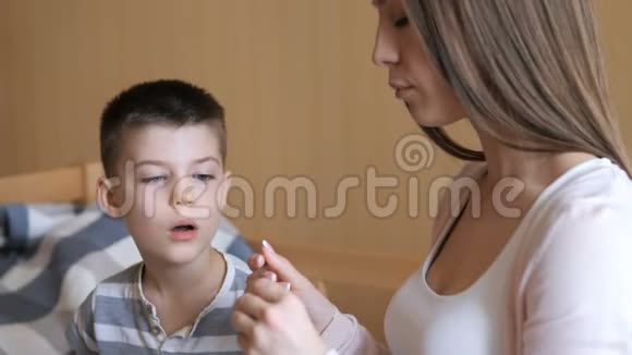 病态的孩子观念妈妈用勺子给她六岁的孩子滴药视频的预览图
