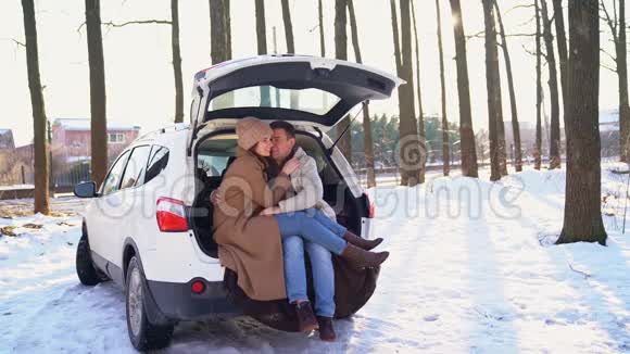 坐在白色汽车后备箱里的男人和女人视频的预览图