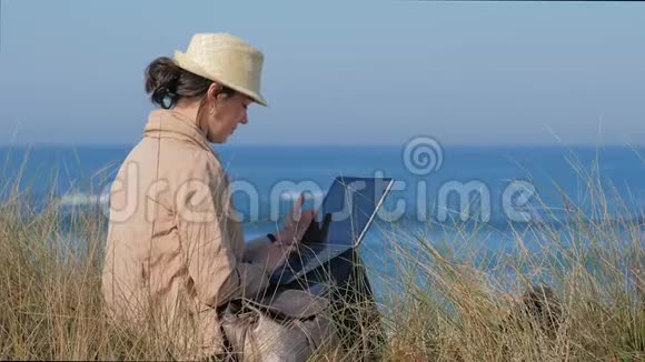 在沙滩上记笔记的自由职业妇女视频的预览图