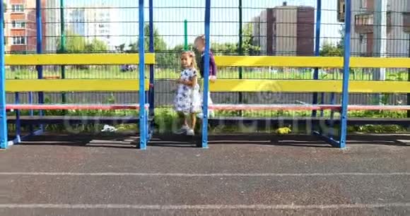 3岁和4岁的女孩在晴朗的天气里在体育场玩耍视频的预览图