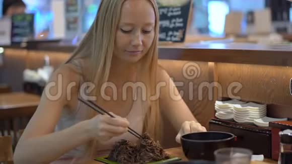韩国餐馆的年轻女子吃传统的韩式或日式面条韩国旅游理念视频的预览图
