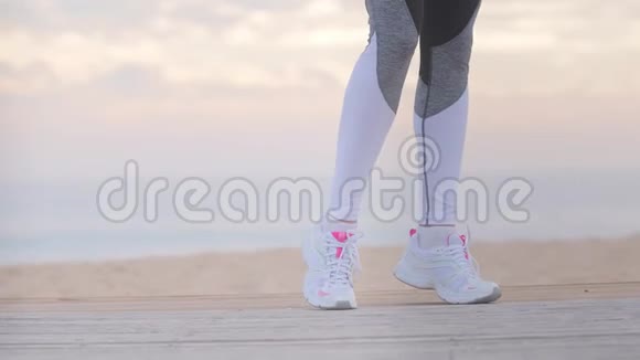 女子伸展运动后在海滨看健身表视频的预览图