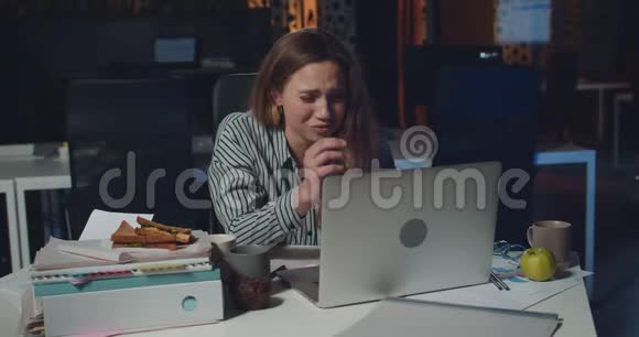 穿着紧身的年轻女人在使用笔记本电脑时因为问题而看起来很难过从事私人工作的沮丧女雇员视频的预览图