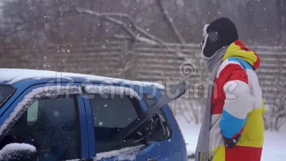 一个年轻人试图把他的滑雪板装在一辆小汽车里但他不到汽车空间不足的概念视频的预览图