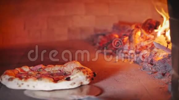 披萨店的主人做一个真正的意大利披萨检查披萨是否准备好用比萨饼从烤箱中取出视频的预览图