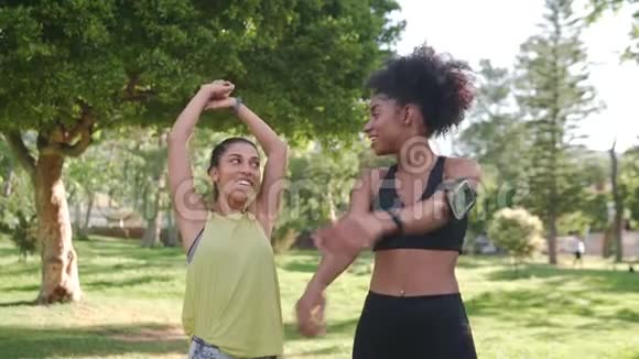 参加健身活动的多种族女性朋友早上在公园里穿着聊天和做伸展运动视频的预览图