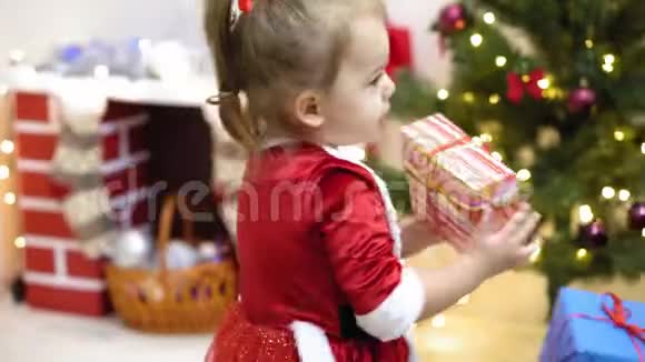 婴儿和怀孕的妈妈把红色的球玩具挂在圣诞树上快乐的童年概念孩子和母亲用视频的预览图