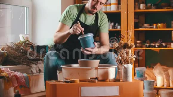 陶器主人正在用蓝色油漆画碗视频的预览图