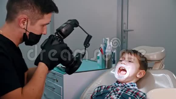一个在牙科治疗的小男孩给男孩的口腔拍照视频的预览图