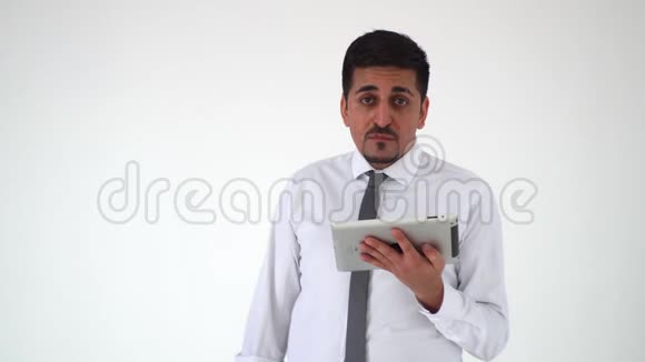 一个满意的人看着一台数字平板电脑对他看到的东西感到沮丧那个痛苦的男人扬起眉毛抓住视频的预览图