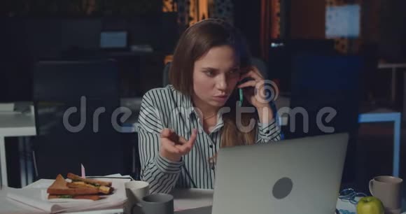 前面看到年轻迷茫的女人在手机上说话看着笔记本电脑屏幕女办公室经理坐着视频的预览图