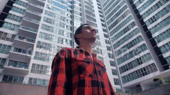 青年专业人士在摩天大楼建筑的城市背景下环顾四周的肖像视频的预览图