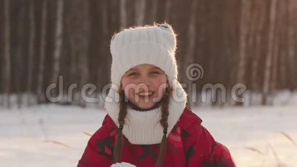 一个小女孩正在把雪从手掌上吹下来微笑着视频的预览图