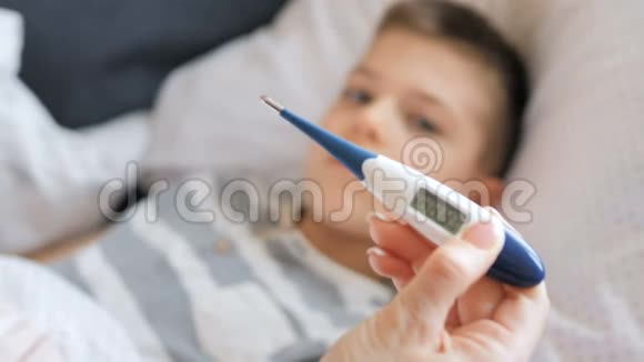 母亲测量生病孩子的体温病儿高烧不退躺在家里视频的预览图