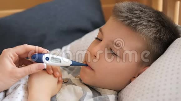 母亲测量生病孩子的体温病儿高烧不退躺在家里视频的预览图