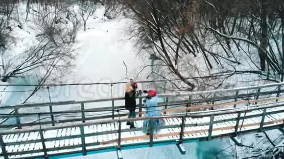 两个年轻的女朋友从桥上的热水瓶里喝热饮料视频的预览图