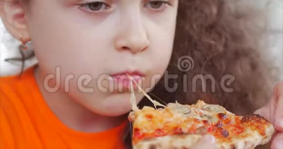 有辫子的小女孩急切地吃一块披萨视频的预览图