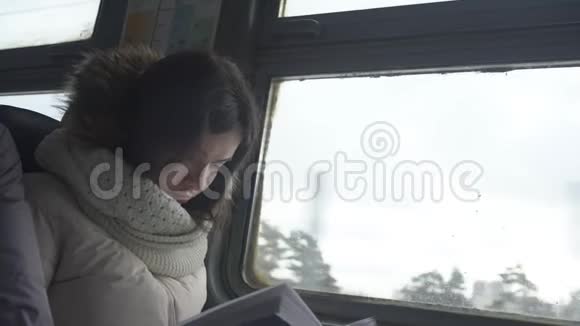 女孩坐火车坐在窗前看书视频的预览图