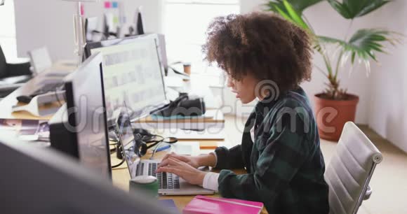 女混血儿在创意办公室敲电脑视频的预览图