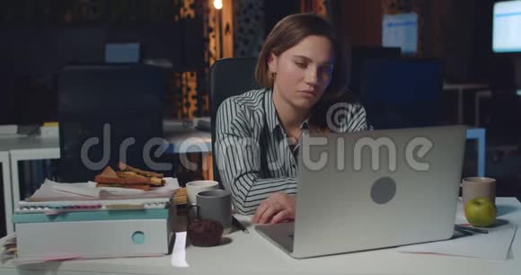 工作过度的妇女办公室经理关闭笔记本电脑并把头放在手上而坐在办公桌上年轻的女商人视频的预览图