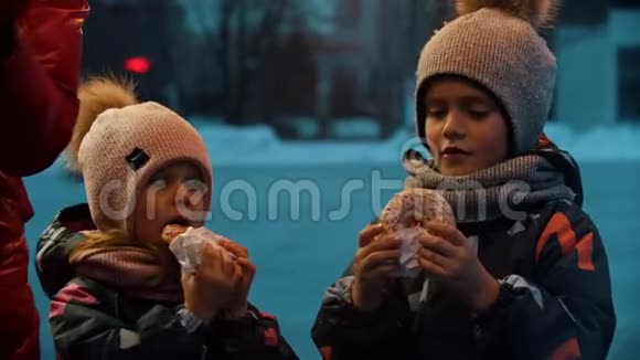 孩子们在冬天在户外吃甜甜圈视频的预览图