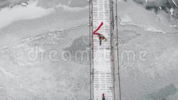 两个五颜六色的女人在雪桥上奔跑视频的预览图
