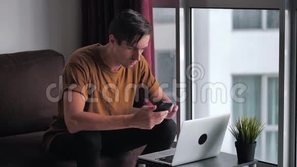 忙碌的年轻人用智能手机和笔记本电脑做电子商务在网上购物看视频电影视频的预览图