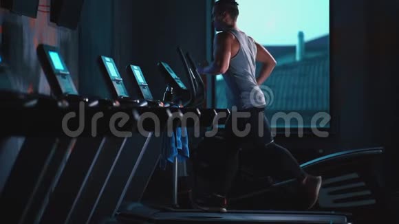 现代健身房跑步机上跑步的帅哥视频的预览图
