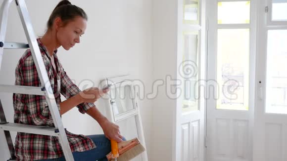 女人想计划决定修理她的房子用平板电脑或手机视频的预览图