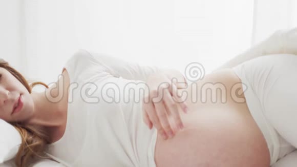 幸福的孕妇抚摸着她美丽的腹部怀孕母性和期望概念视频的预览图