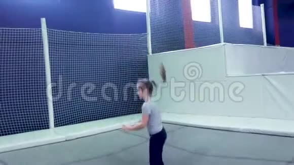 小女孩在蹦床上蹦极在游戏中心蹦极视频的预览图