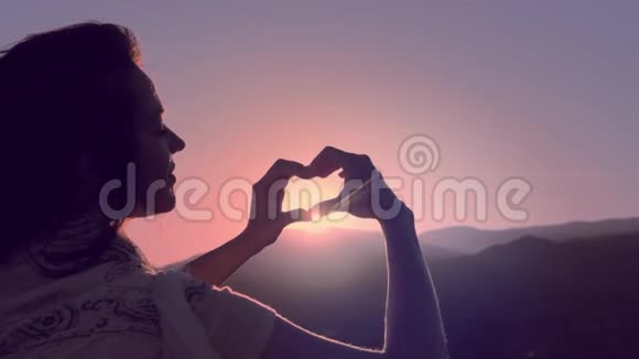 女性手以心的形式向天空传递阳光视频的预览图