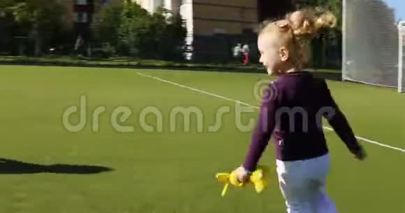 两个浅棕色的女孩逃离了摄像机躲在足球球门后面视频的预览图