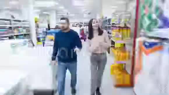 在超市的一对年轻夫妇视频拍摄的加速形式使用时间推移技术视频的预览图