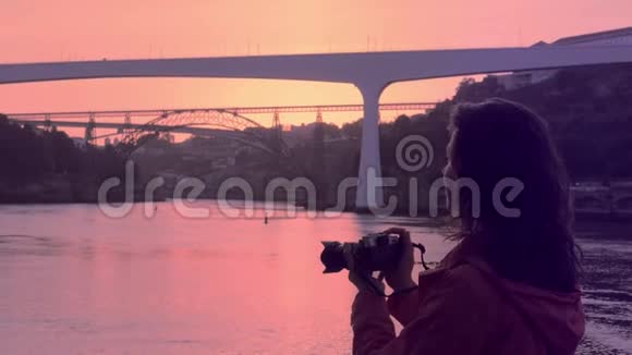 日落波托码头拍照的年轻女子视频的预览图