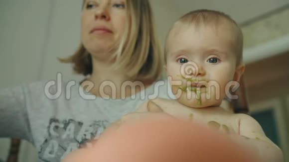 年轻母亲用勺子喂养她的宝贝女儿视频的预览图