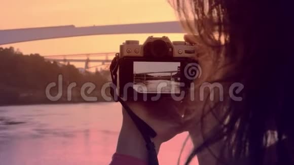 日落时分一位年轻女子在波尔图著名的桥上拍照视频的预览图
