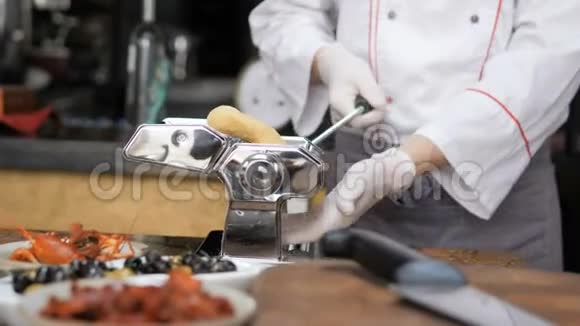 厨师的手使用意大利面切割机从意大利面机出来的新鲜意大利面视频的预览图