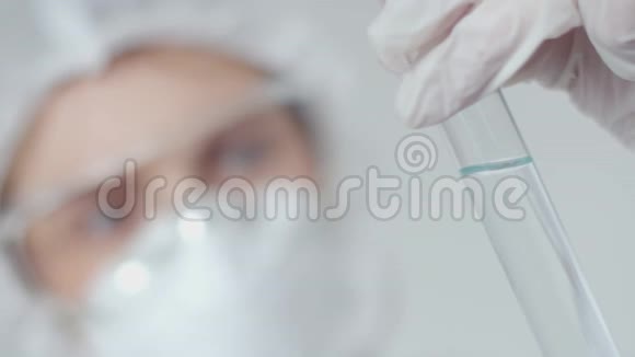一位女教授将血液注入试管中并用溶液进行分析一个戴纱布面具的女人视频的预览图