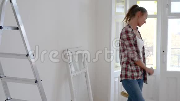 女孩在公寓里修理跳舞女人在墙上画画视频的预览图