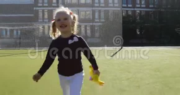 一个穿着白裤子的三岁金发女孩正笑着在摄像机后面欢快地奔跑视频的预览图