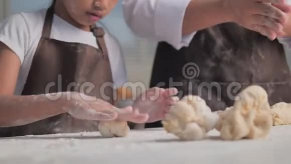 母亲和一个女儿揉面包店的面团视频的预览图