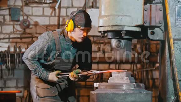 锻造工业一个铁匠把铁块置于大机器的压力下制造一把刀视频的预览图