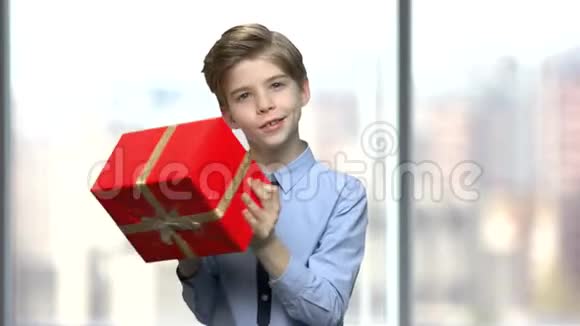 男孩拿着礼物摇着一个盒子视频的预览图