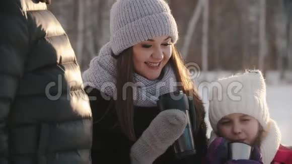 一家四口人在冬天喝热饮料一个小女孩在笑视频的预览图