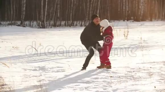一位父亲和母亲在冬天的户外玩耍视频的预览图
